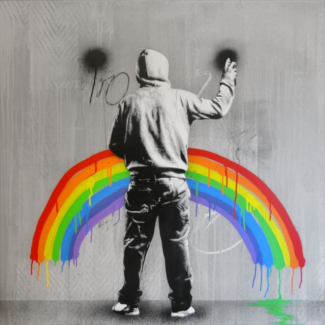 Untitled (person wearing a hoodie, painting a rainbow)